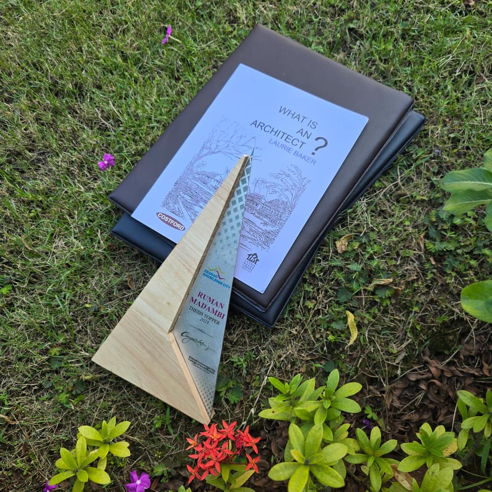 Thesis Topper 2025 trophy from Eranad Knowledge City, beside Laurie Baker’s book What Is an Architect?